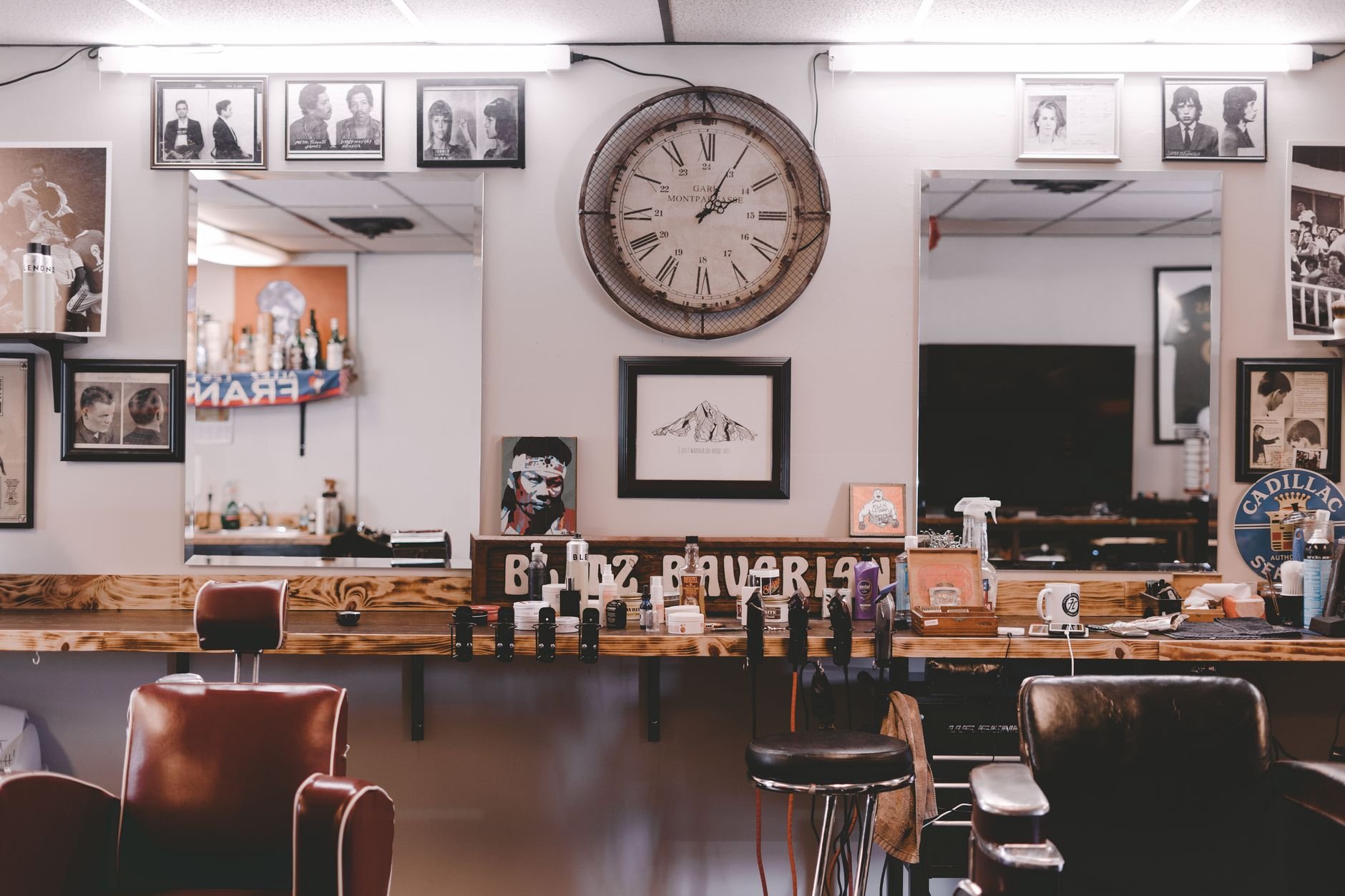 Stylish cozy interior design of modern hairdressing studio or barbershop with leather chairs stylish souvenirs and framed photos on walls.