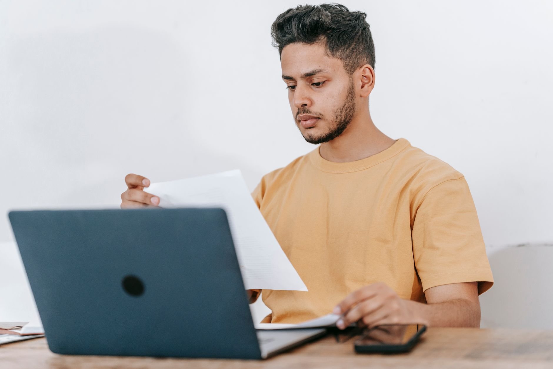 Barber entrepreneur reviewing business growth strategies with documents and laptop.